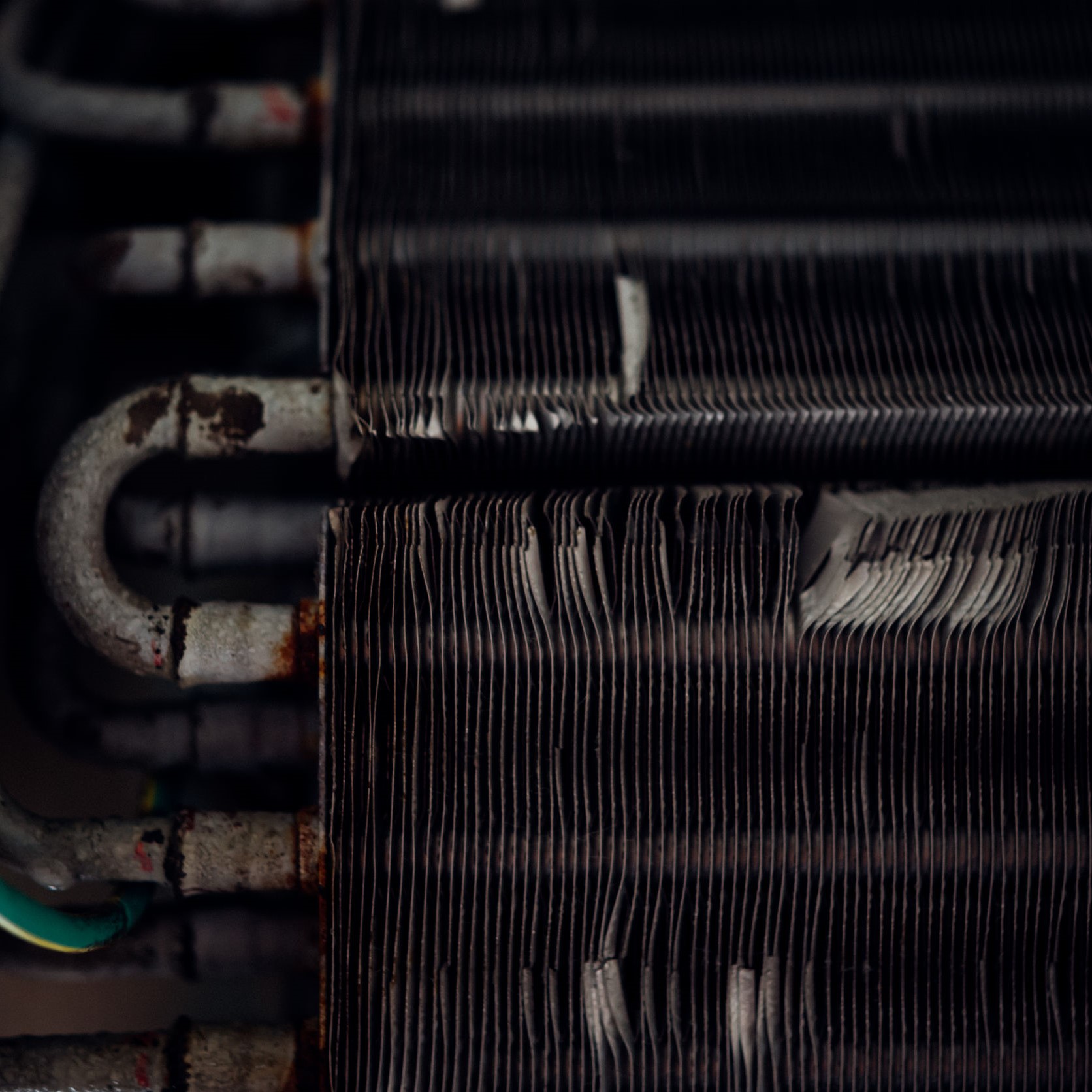 A close up view of air conditioner coils in need of a cleaning.