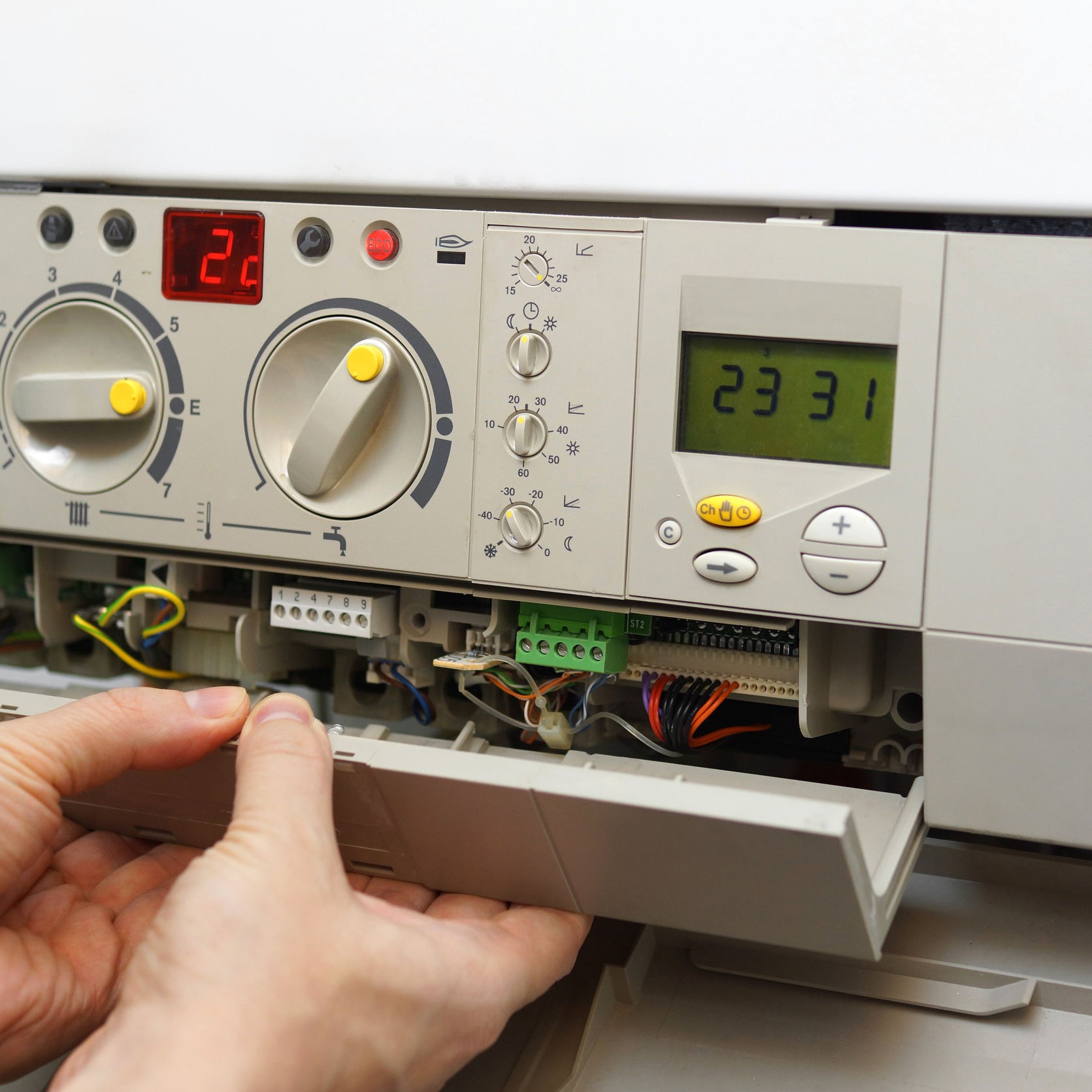 A furnace being opened, in order for a repairman to evaluate it.