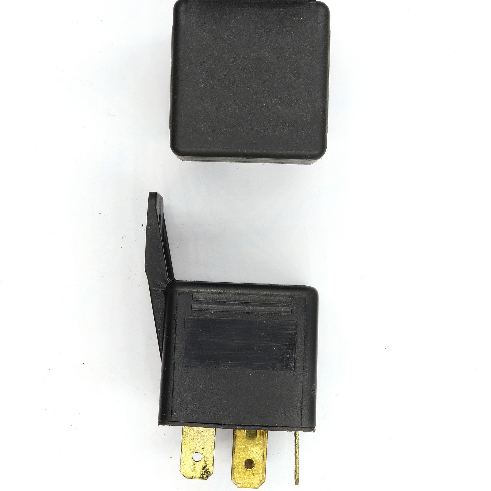 Two relays on a table, where you can see the top of one and the side of another.