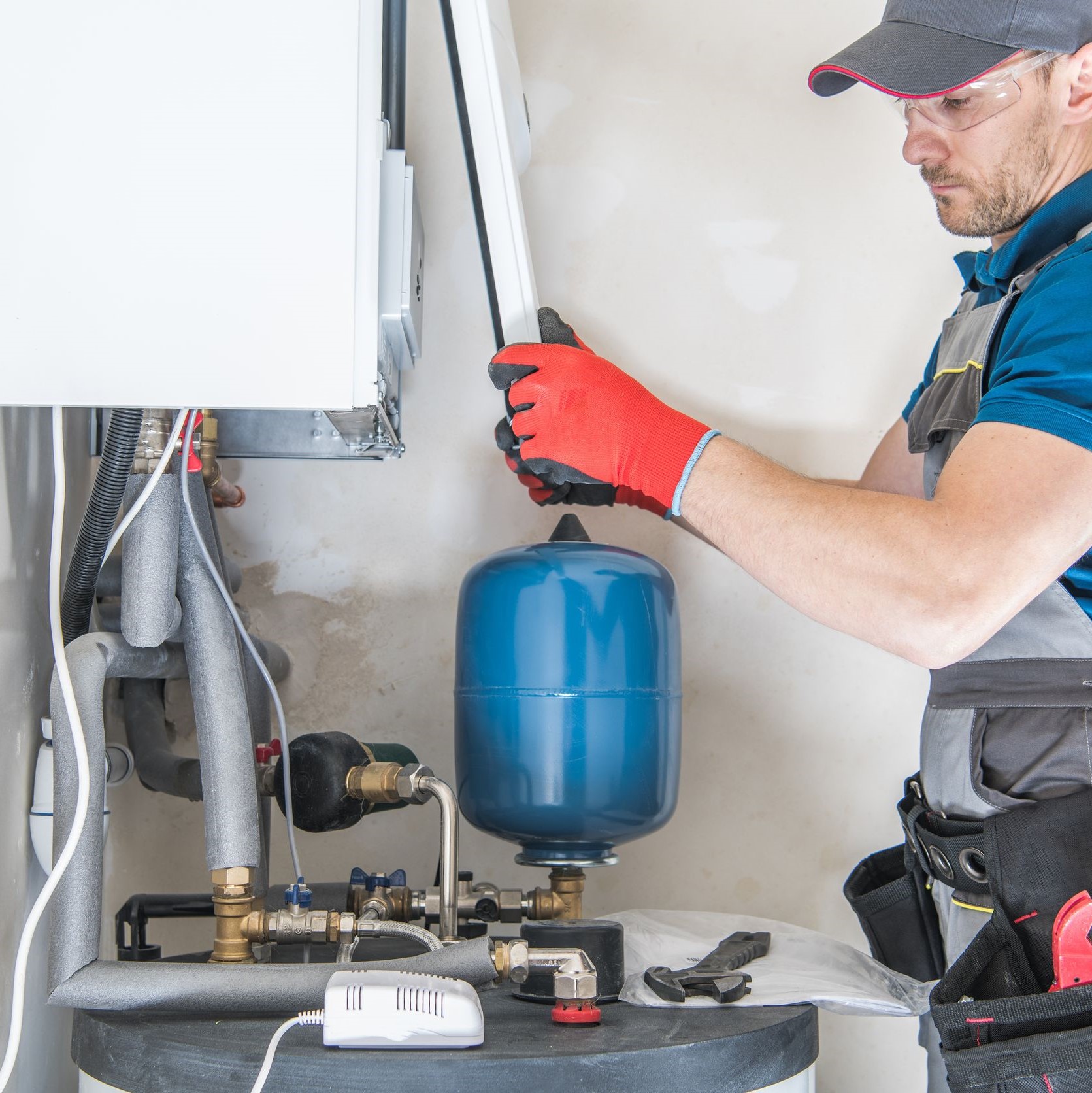 A technician fixing a furnace in a house.